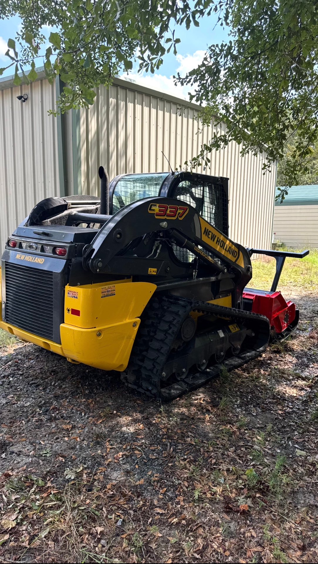 New Holland C337 skid steer with the mulcher head.