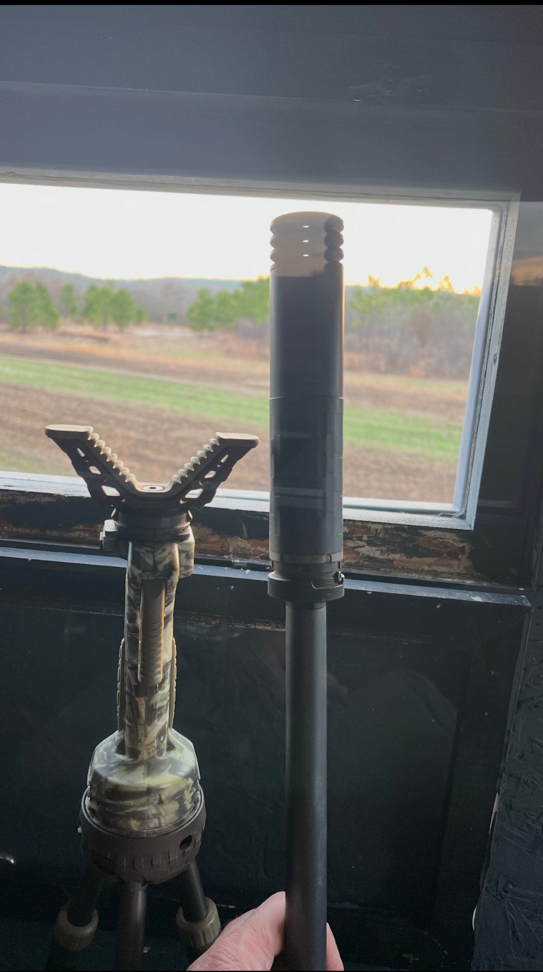 View from the shooting house window with a suppressed rifle.