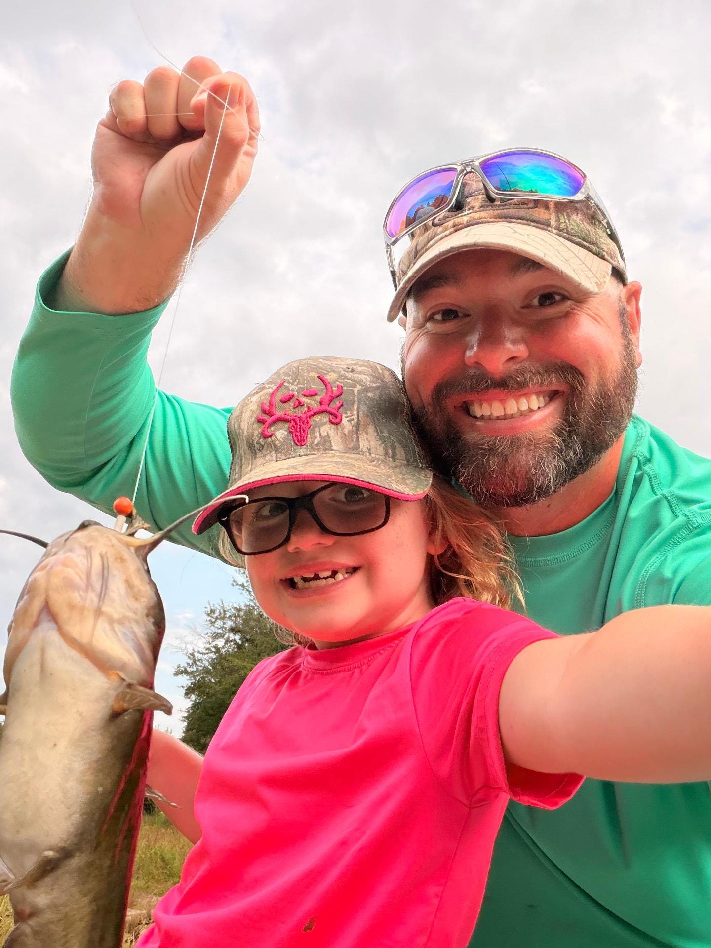 Father and daughter with a catfish from the pond.