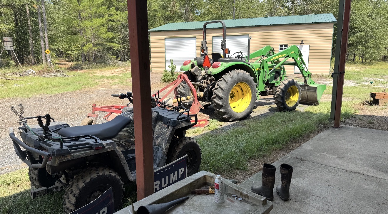 The work fleet — tractor, bushhog and ATV at camp.